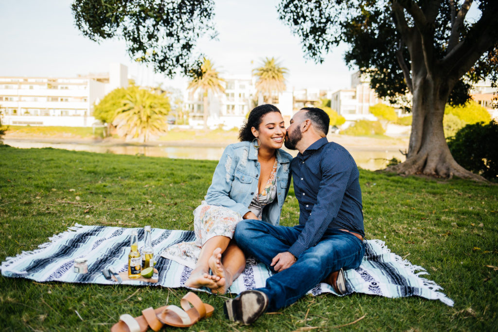 Engagement photo idea: kiss on a picnic blanket and bring snacks