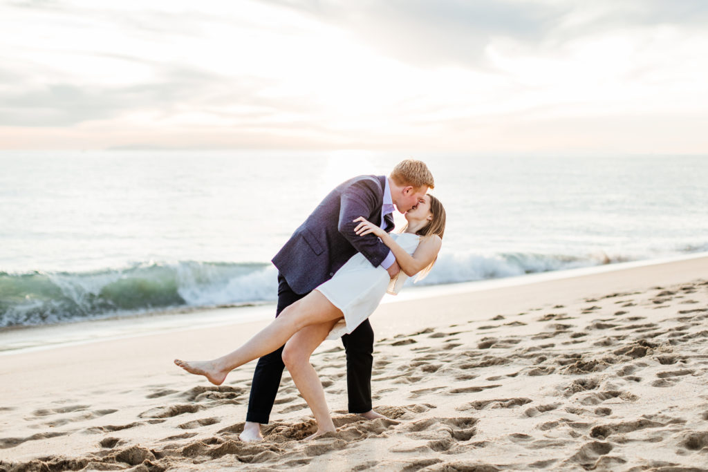Newport Beach engagement photos: groom dipping bride by the ocean