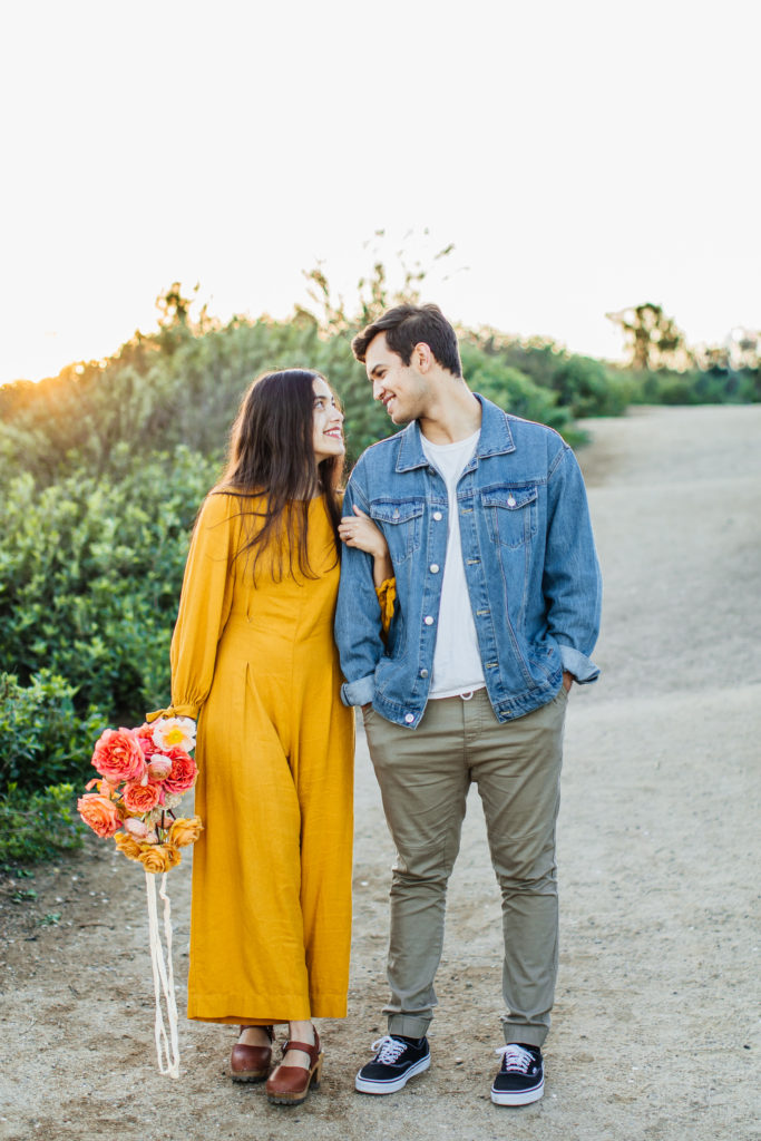 Newport back bay couples session: couple with colorful flowers standing in trail