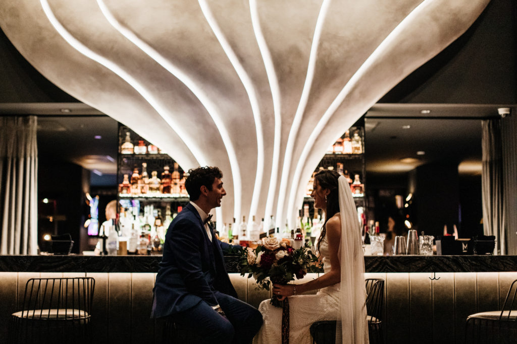 mayfair hotel wedding in downtown Los Angeles picturing bride and groom sitting art the bar together