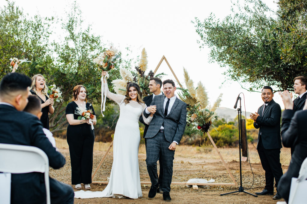 San Diego wedding on a private estate picturing bride and groom celebrating after their first kiss as husband and wife