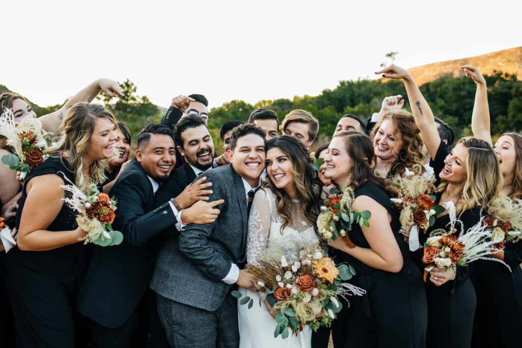bridal party group hugs bride and groom