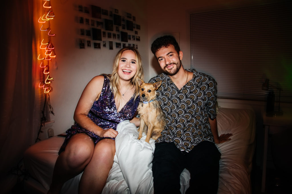 couple smiles with their pup for a sweet engagement photo