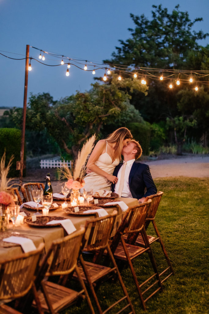 microwedding in Paso Robles at a tuscan villa, bride and groom kiss under string lights