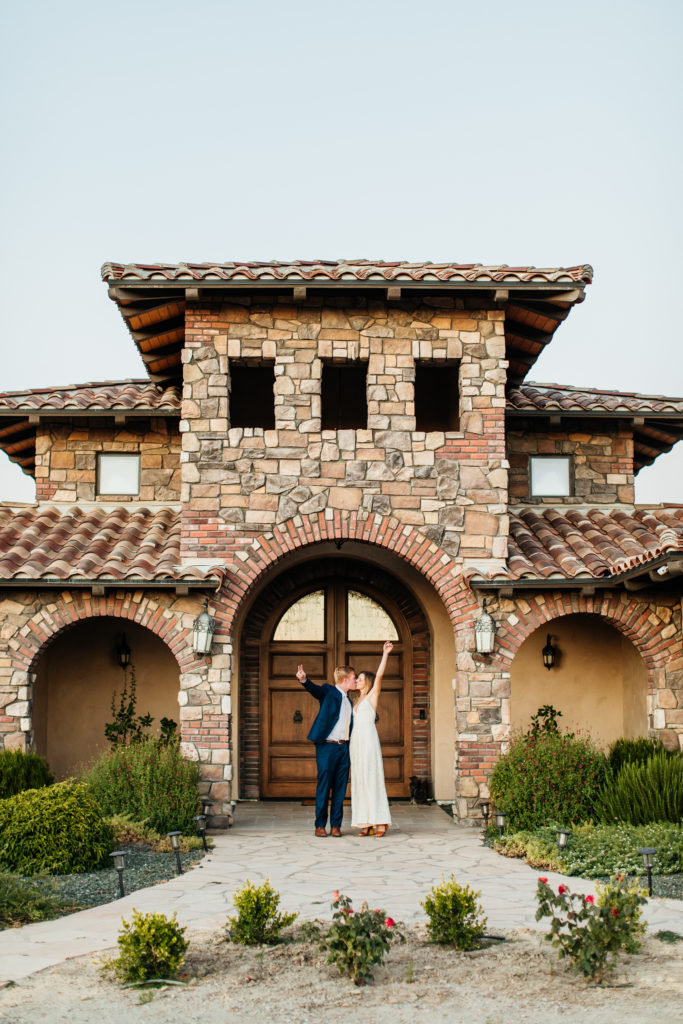 bride and groom kiss in front of their tuscan villa wedding venue 