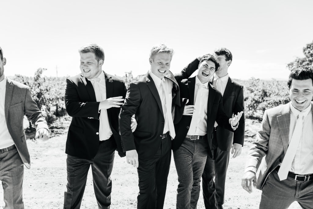 groomsmen smile and laugh for a picture