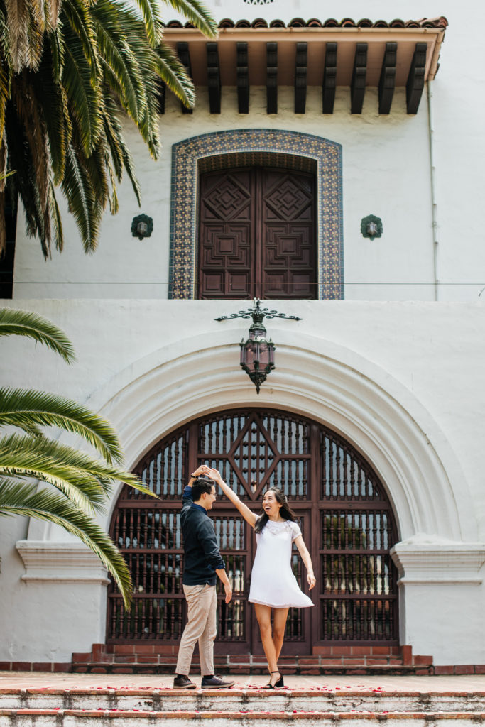 groom twirls bride for candid photo at the Santa Barbara courthouse