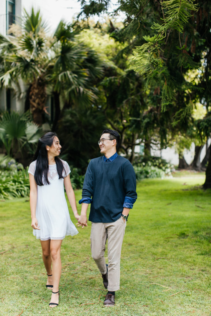 bride and groom hold hands and stroll during their engagement photos