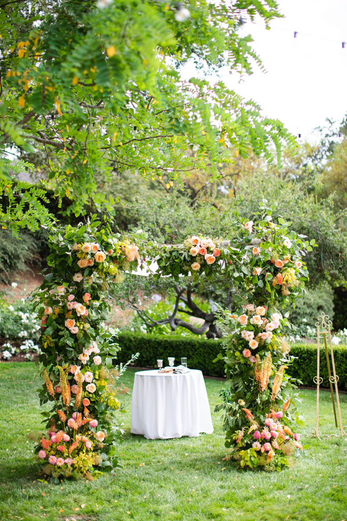 wedding chuppah decorated with bright pink and coral florals