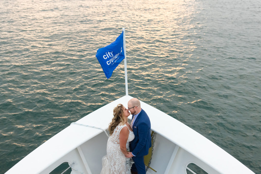 bride and groom smiling at each other on a boat cruise