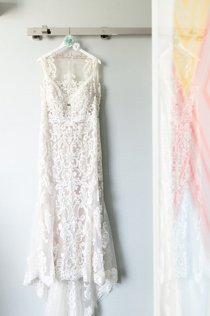 wedding dress hanging on special hanger with bride's new last name