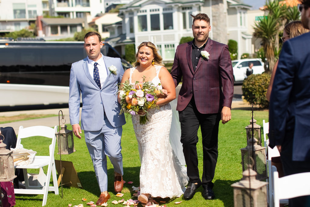 bride walking down the aisle with her brothers