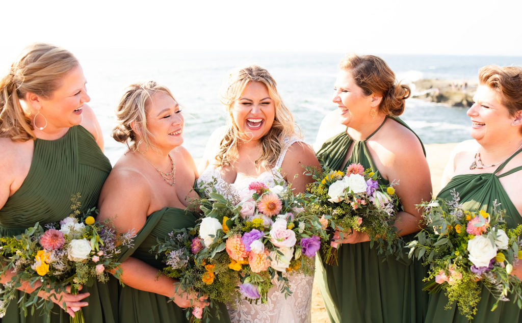 bridesmaids laughing together with colorful bouquets