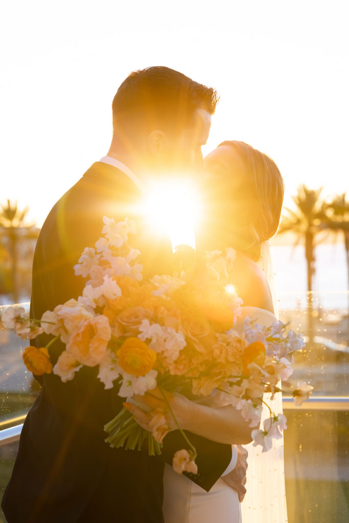 bride and groom kiss at sunset wedding in San Diego