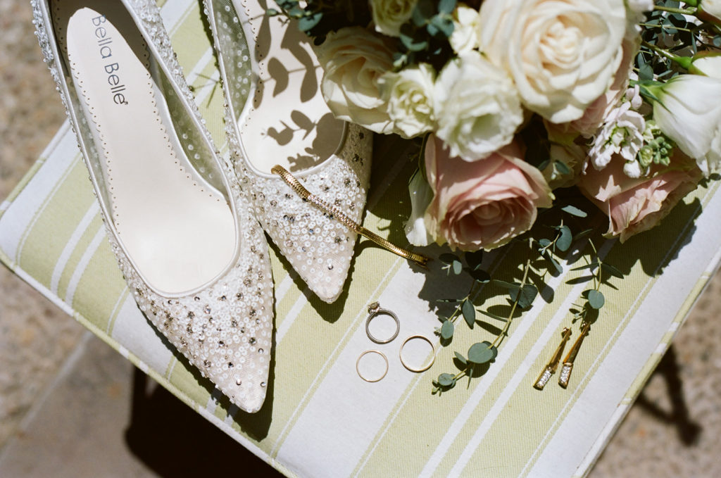 detail photo of bride's shoes, jewelry, and flowers