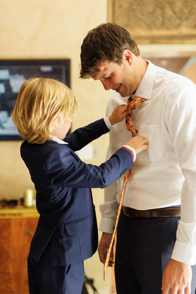 groom's son helps him get ready for the wedding