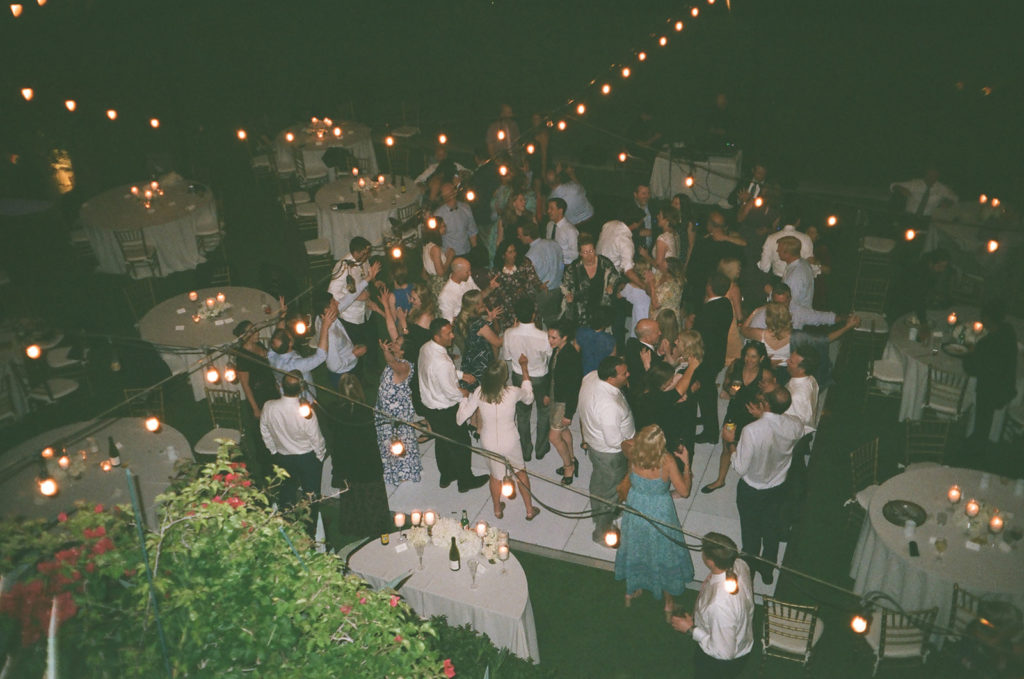 wedding guests dance under string lights