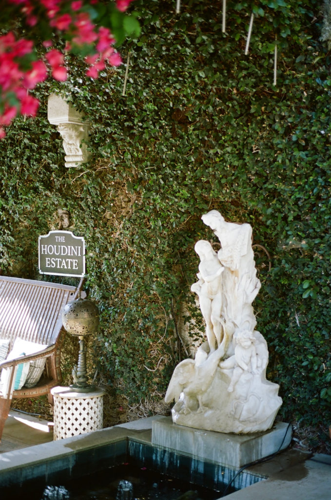 picturesque statues at the Houdini estate surrounded by greenery and colorful florals