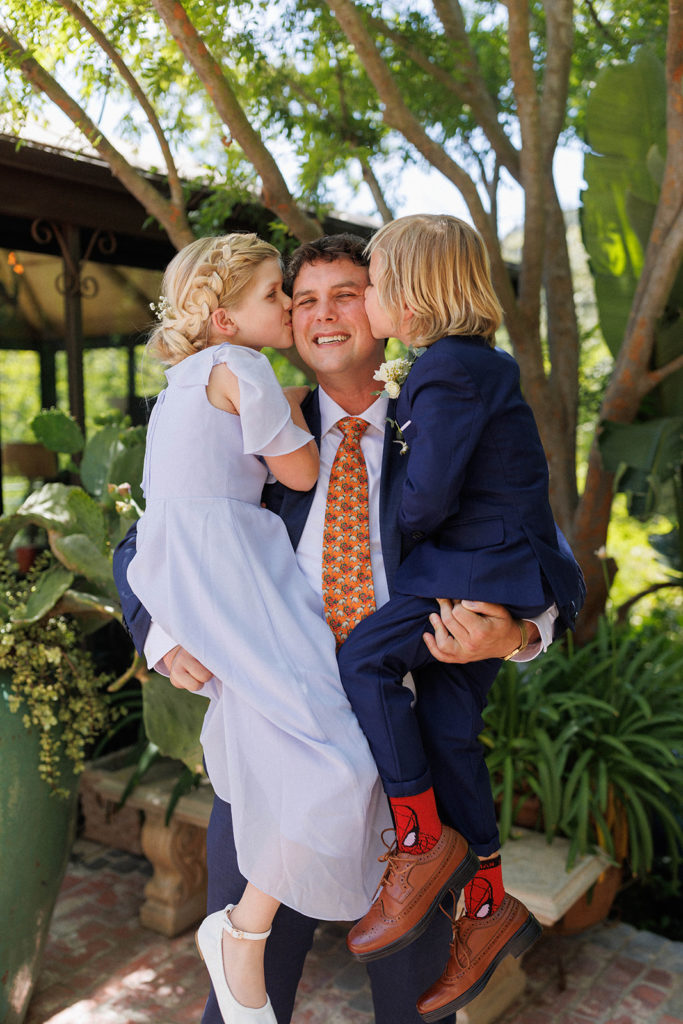 groom hugs his children during getting ready at his wedding