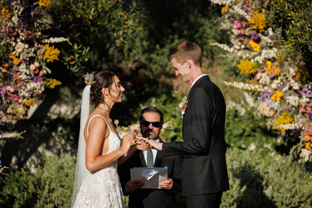bride and groom exchanging weddings at the harper wedding in Orange County