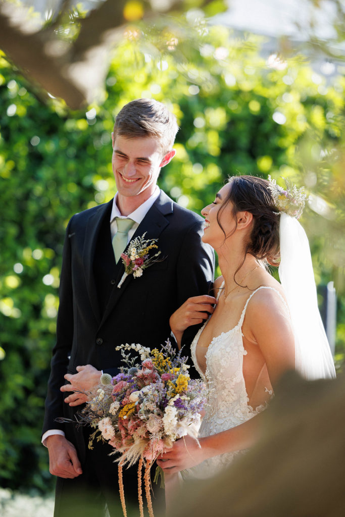 bride and groom laugh together during wedding ceremony