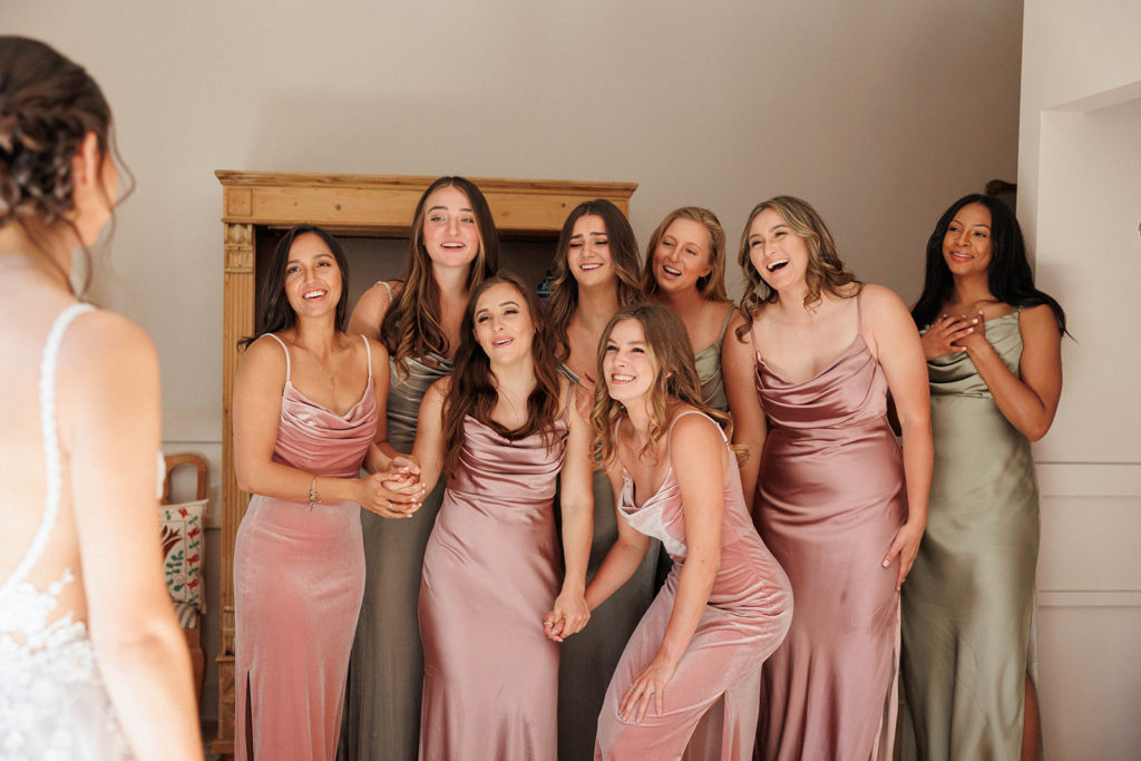 bridesmaids have first look with bride to see her dress