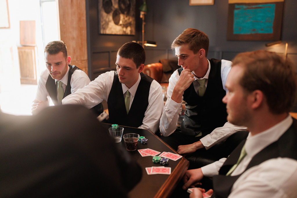 groomsmen playing poker together at wedding