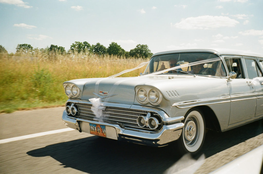 wedding party drives to ceremony in a vintage car