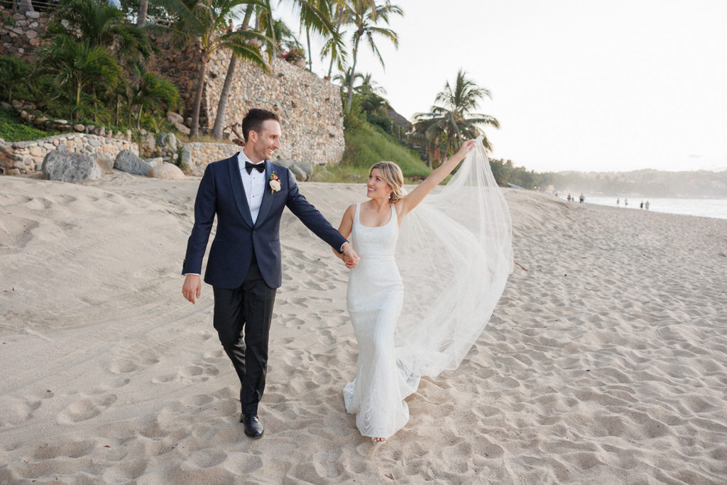 bride and groom enjoy the beach together at sunset in mexico 