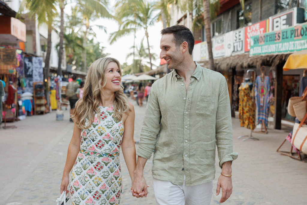 couple strolls through town together before their rehearsal dinner in mexico
