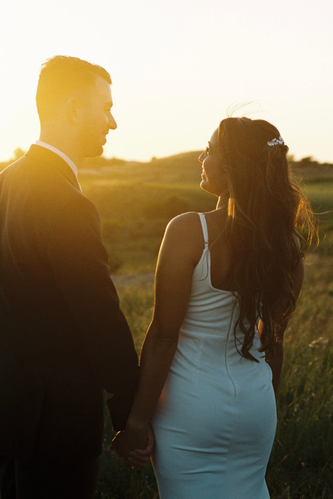 bride and groom laughing together at sunset