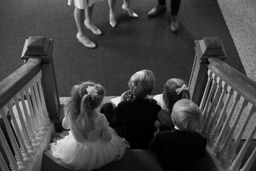 candid photo of kids waiting for wedding ceremony highlighting why you should hire a documentary style wedding photographer