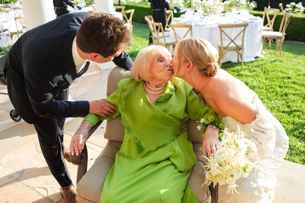 grandmother kisses bride at wedding