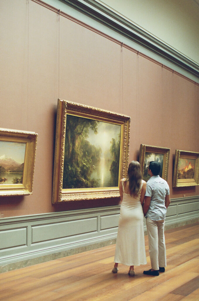 couple gazes at a European painting together in a museum