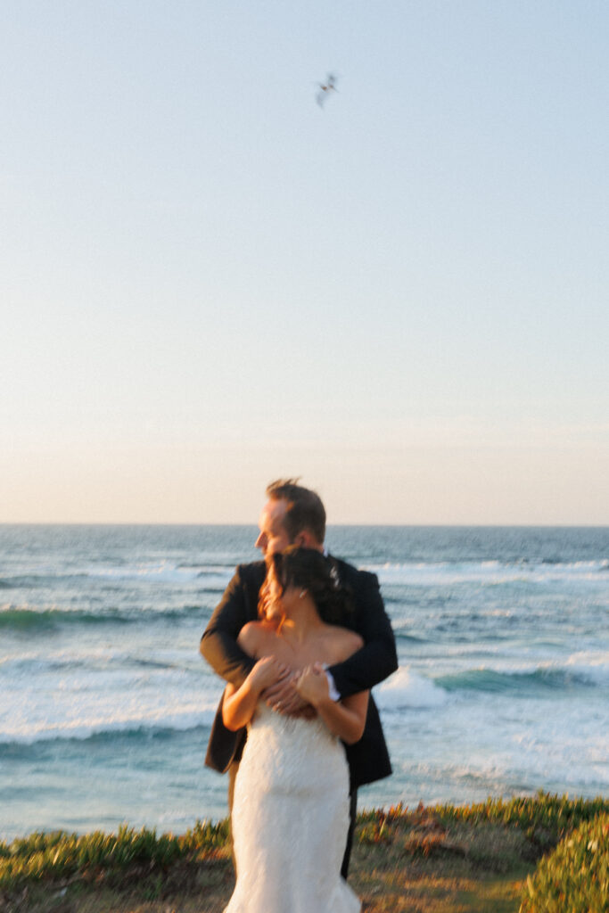 bride and groom embrace during sunset on the beach