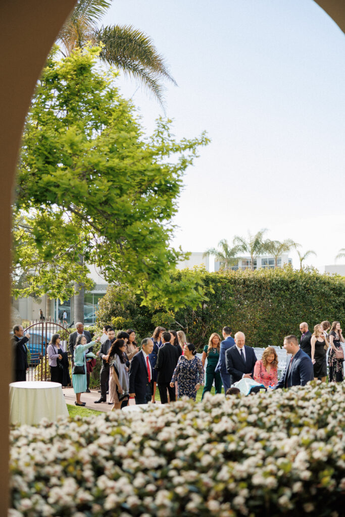 guests gather before wedding ceremony in a garden