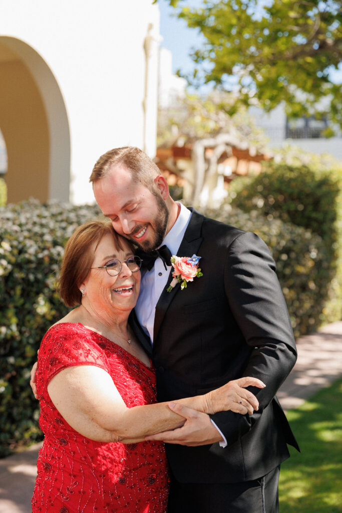groom shares a sweet candid moment with his mother