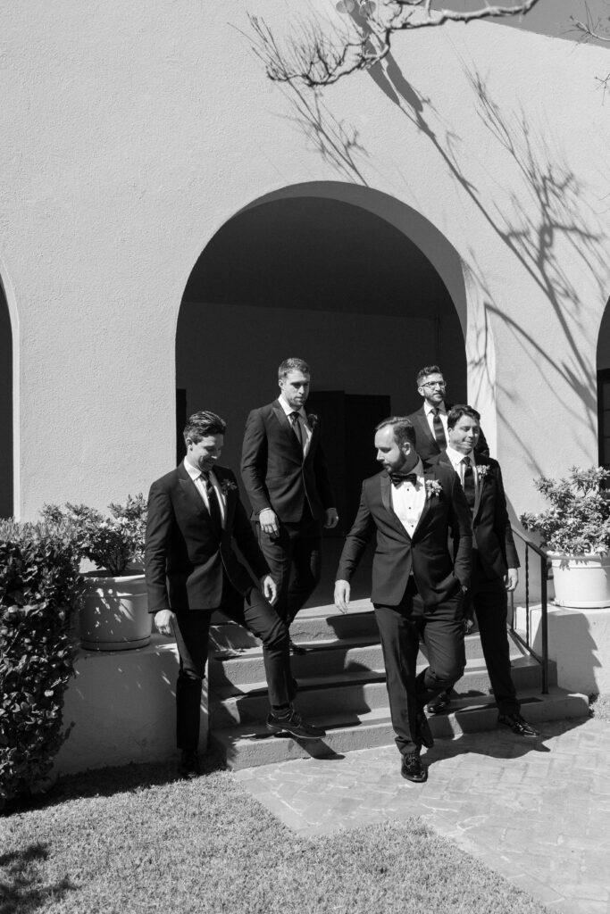 groomsmen walk together in their matching suits