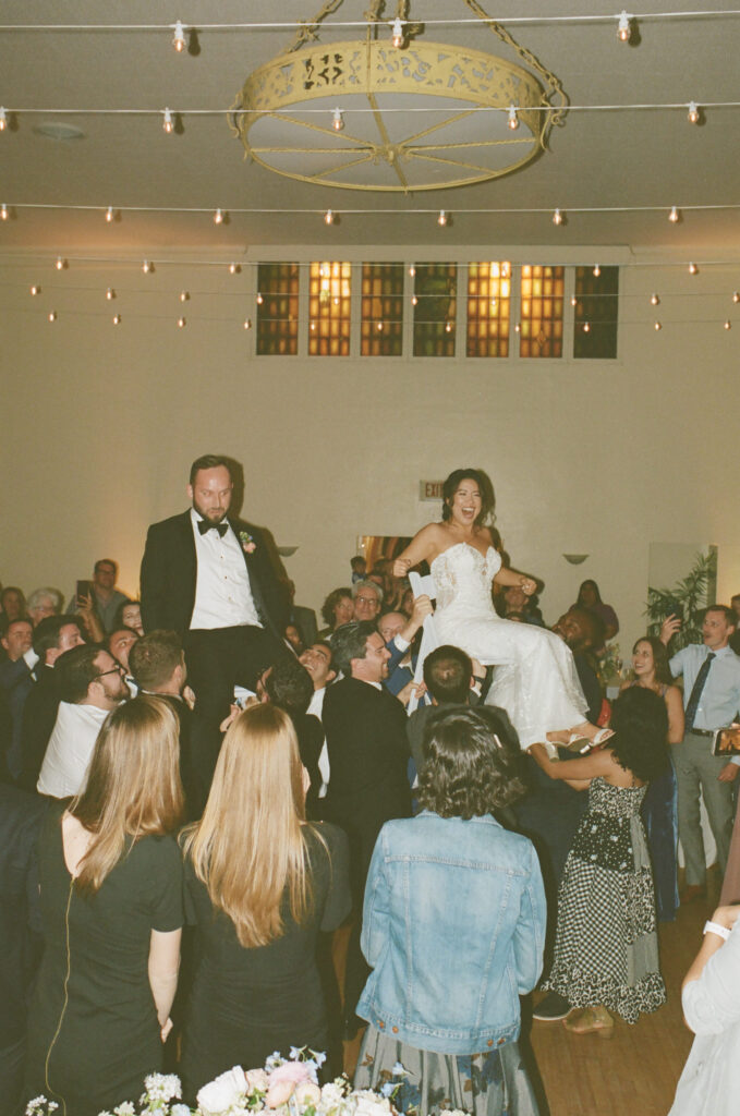 bride and groom doing the hora high above the crowd