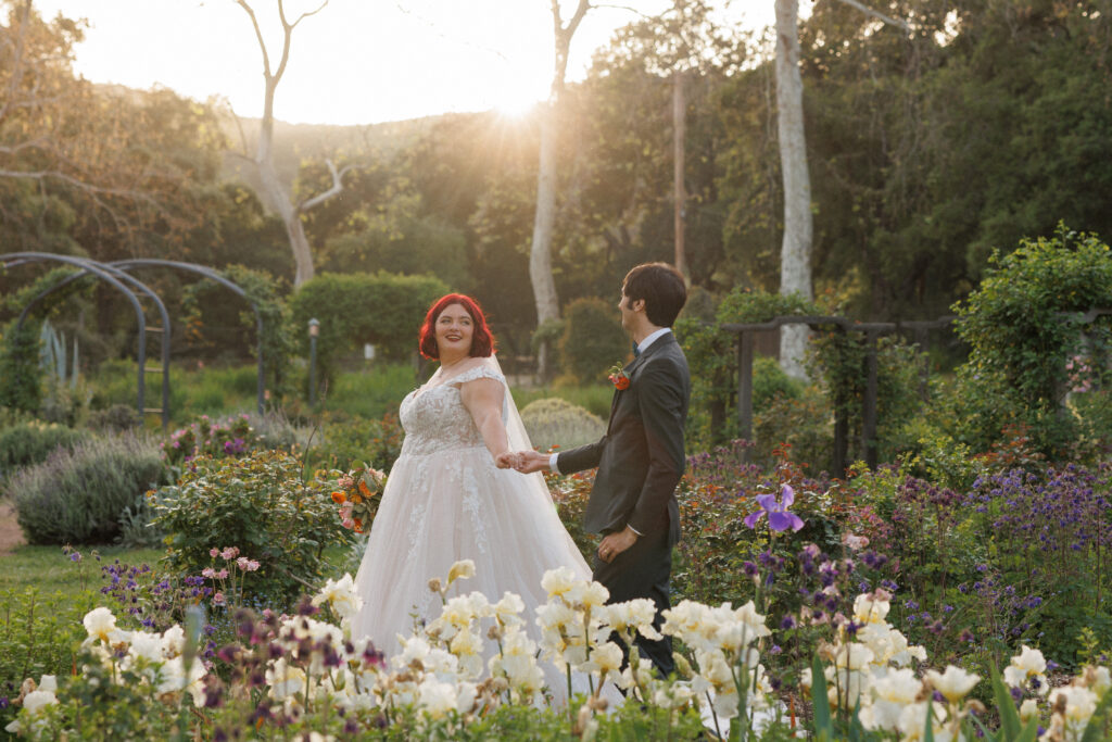 couple strolls through a romantic garden on their wedding day