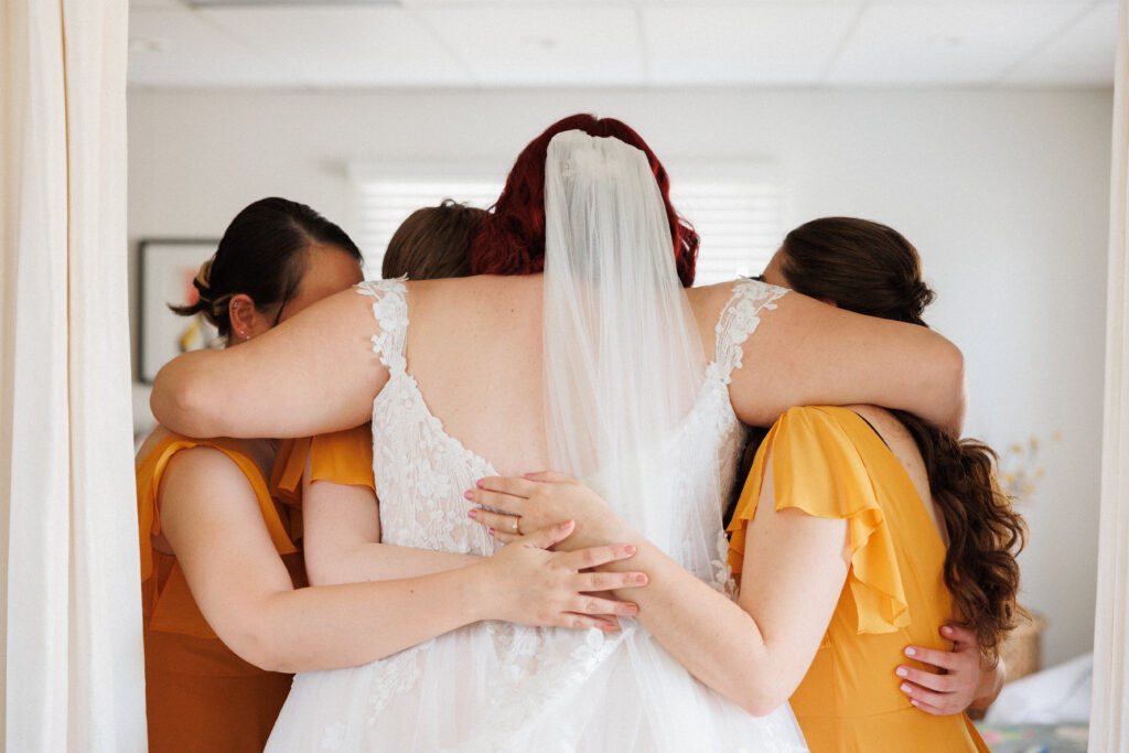 bride embraces her bridesmaids