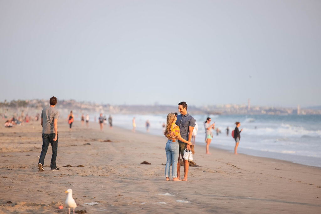 couple walks down the beach in Santa Monica, about to get engaged