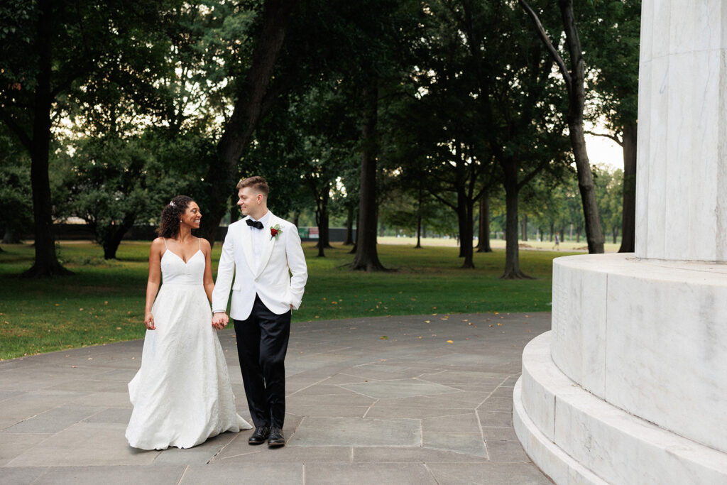 bride and groom walking outdoors at a historical monument