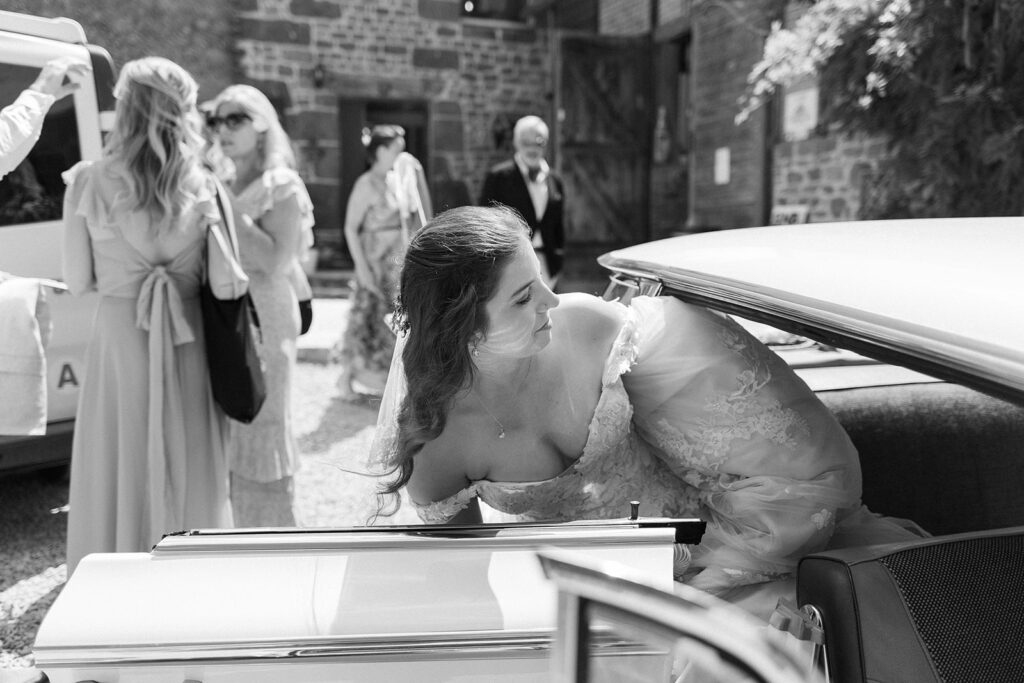 bride gets into classic car on her wedding day in france