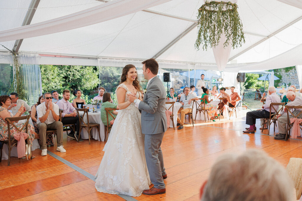 bride and groom enjoy their first dance under a tent in the countryside of france