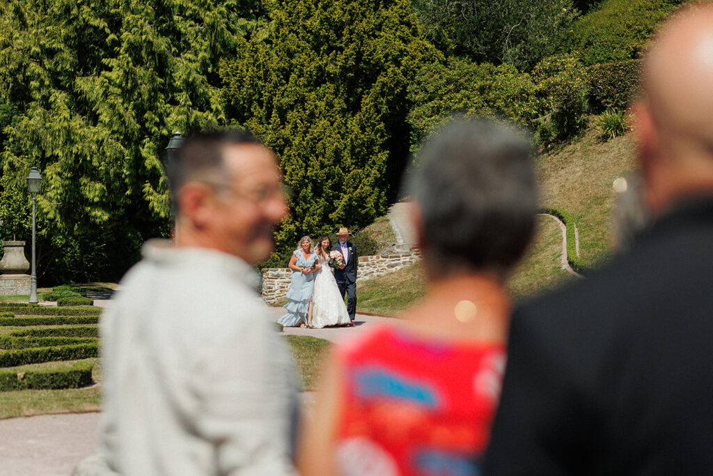 bride and her parents walk down the aisle at French wedding 