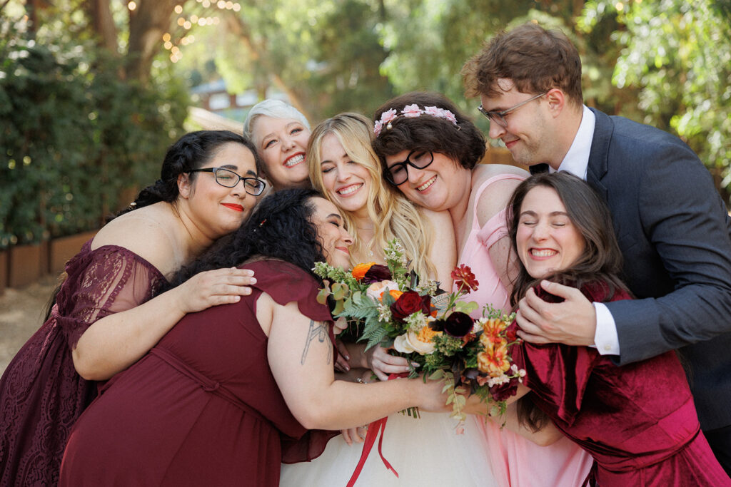 brides people snuggle the bride for a sweet hug during this Malibu wedding day