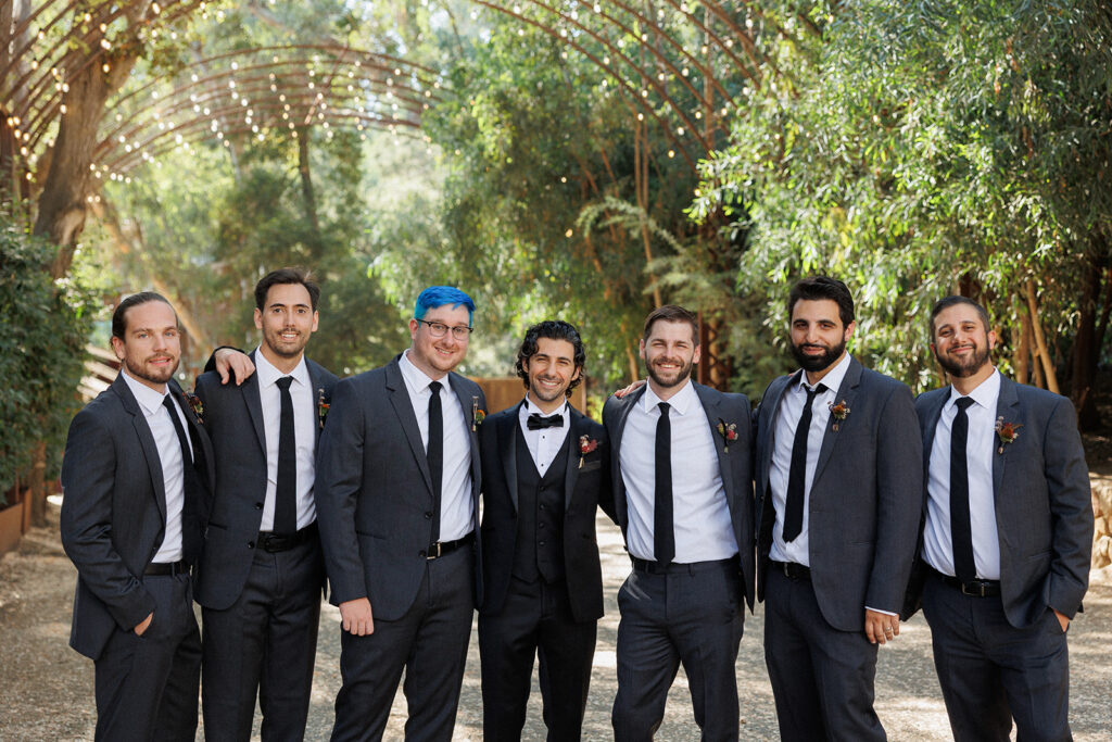 actor Noah James smiles with his groomsmen for a sweet photo at this Malibu wedding