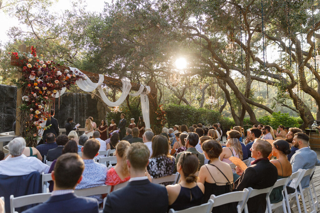 sunlight filters through the oak trees during renaissance-inspired wedding ceremony in Malibu