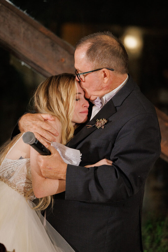 father of the bride embraces his daughter after an emotional toast at this Malibu wedding at Calamigos Ranch